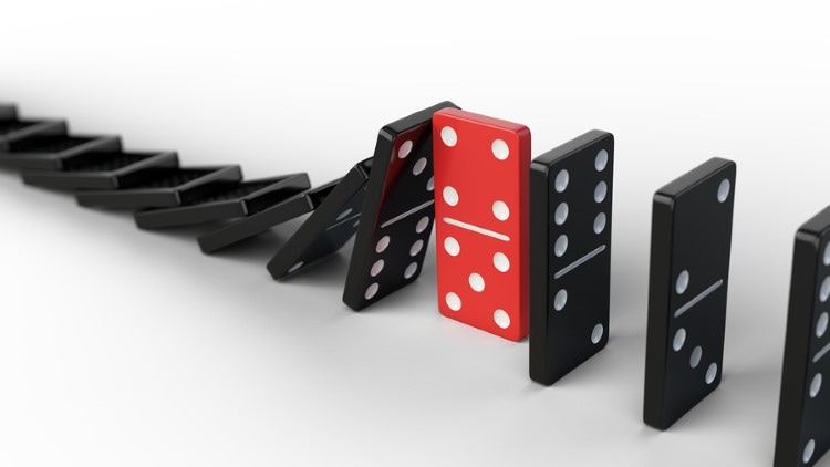 Leadership and teamwork concept – Red domino stops falling other Dominosteine